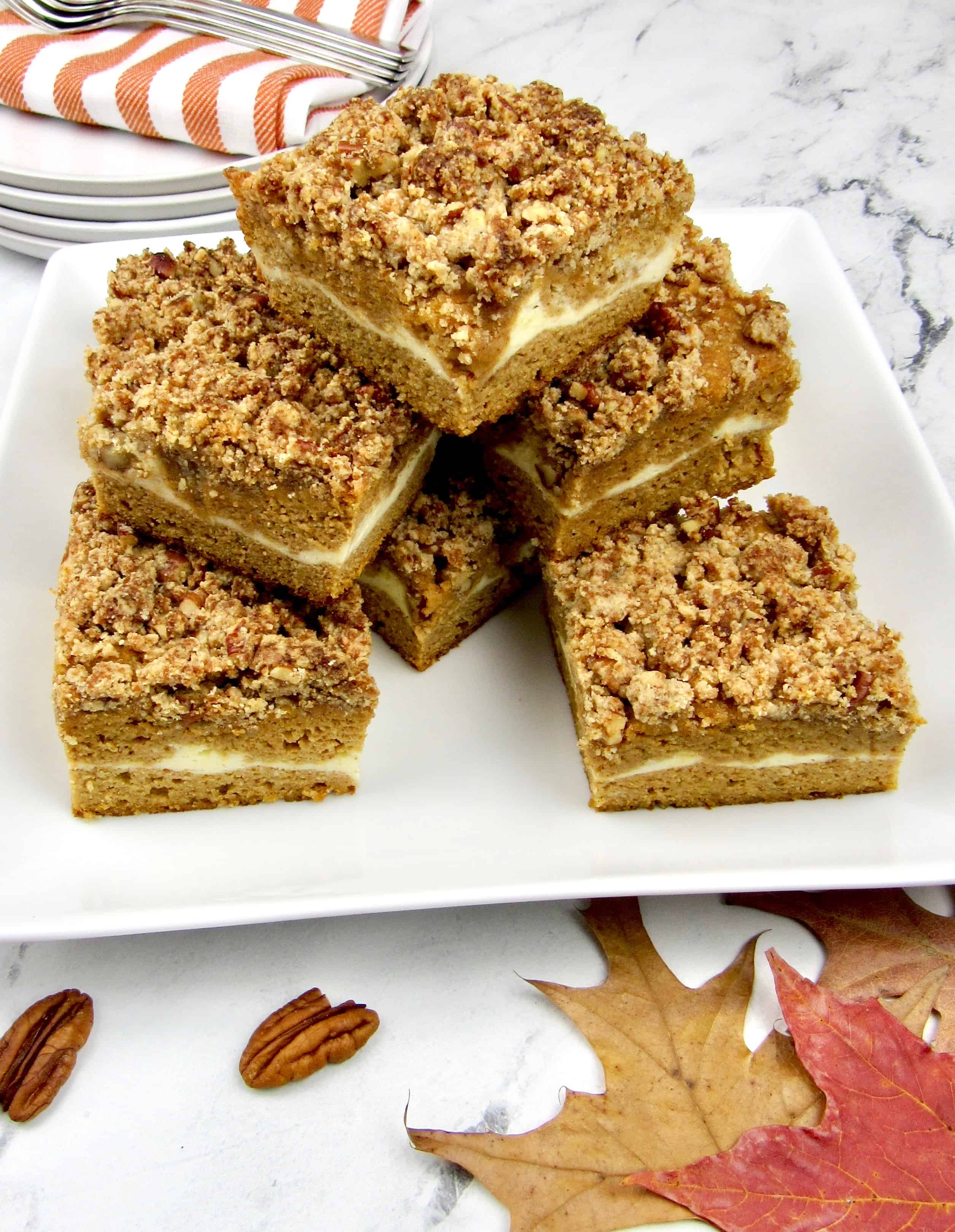 slices of pumpkin coffee cake stacked up on a square plate