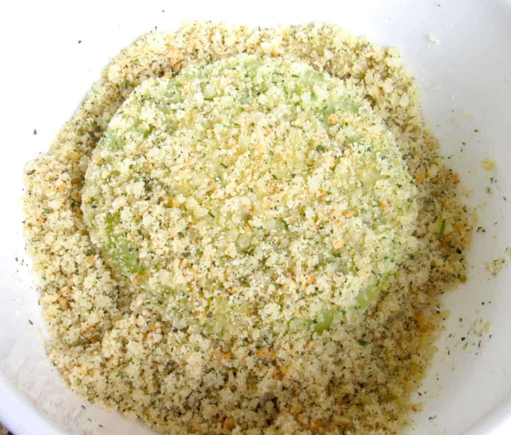 green tomato in breading in white bowl