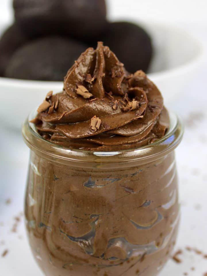 avocado mousse in jar with bowl of avocados in background