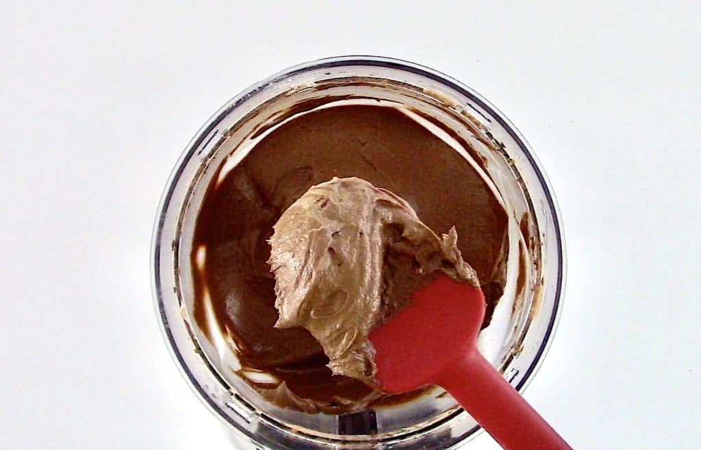 avocado mousse being spooned out of food processor