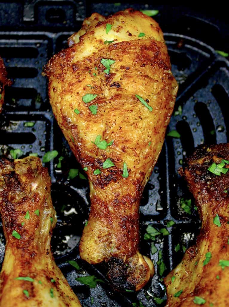 closeup of cooked chicken leg with parsley on top