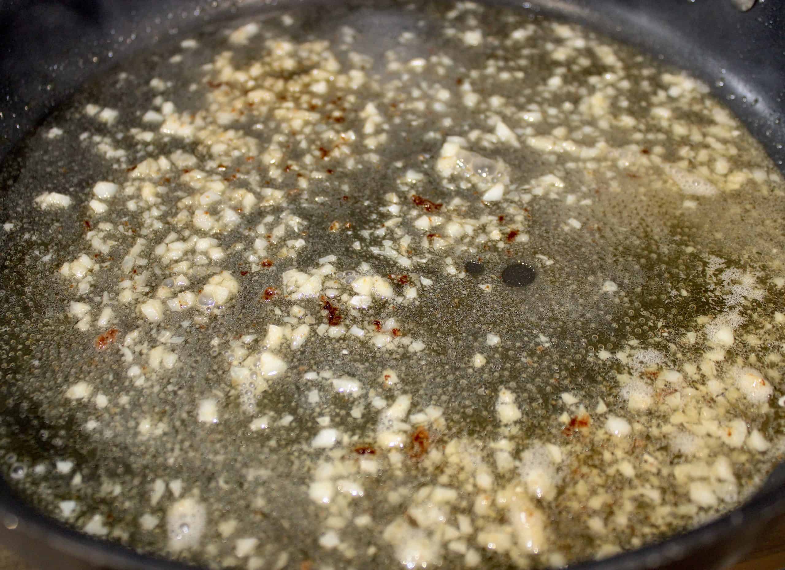 garlic and white wine in skillet