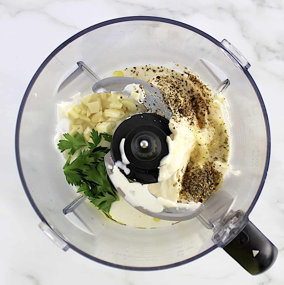 overhead view of Creamy Garlic Italian Dressing ingredients in food processor unmixed